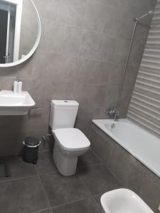 y baño con aseo, lavabo y bañera. en Apartamento Almijara, en Torre del Mar