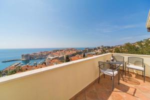 balcón con mesa, sillas y vistas al océano en Apartment Varina, en Dubrovnik