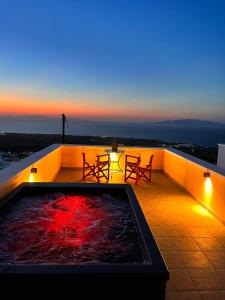 un bain à remous sur le toit d'un immeuble au coucher du soleil dans l'établissement Sunset Paradise Oia, à Oia
