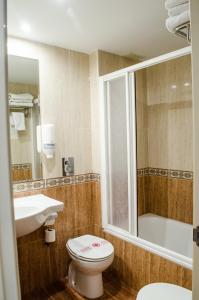uma casa de banho com um WC, um lavatório e uma banheira em Hotel Jaqués em Jaca