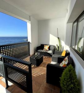 balkon z kanapami i widokiem na ocean w obiekcie Moderno apartamento frente al mar w Puerto de la Cruz