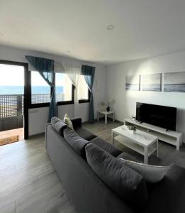 salon z kanapą i telewizorem w obiekcie Moderno apartamento frente al mar w Puerto de la Cruz +29 zdjęć