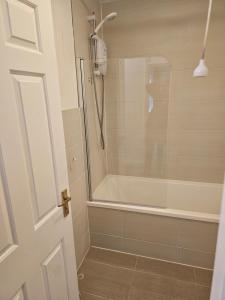 a bathroom with a shower with a glass door at 1 bed modern flat in Didcot