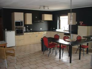 a kitchen with a table and red chairs in it at appartement Courcelles in Courcelles