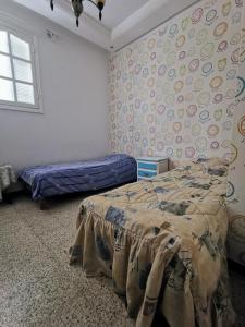 a bedroom with a bed and a wall covered in stickers at Appartement standing Nabeul in Nabeul