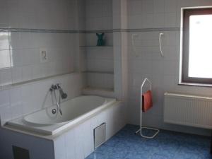 baño blanco con bañera y ventana en appartement Courcelles, en Courcelles