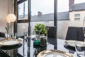 a dining room table with glasses and plates on it at Modern flat in Eastwood Town centre in Eastwood