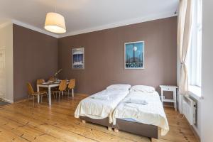 a bedroom with a bed and a table and chairs at Apartamenty Kopernika in Toruń