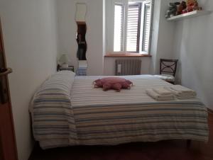 a bed with a pink stuffed animal laying on it at Casa Azzurra in Orbetello