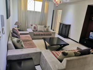 Sala de estar con 2 sofás y mesa en Appartement standing Nabeul en Nabeul