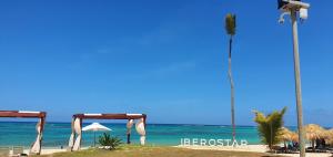una playa con una tienda, una palmera y el océano en Iberosta Villa 4BDR Pool, Jacuzzi - BONUS GolfCart FREE in April, en Punta Cana