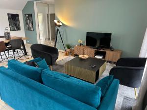 - un salon avec un canapé bleu et des chaises dans l'établissement L'escale du Trianon, au Plessis-Robinson