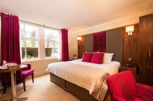 a bedroom with a bed and a table and a window at Kildonan Lodge Hotel in Edinburgh