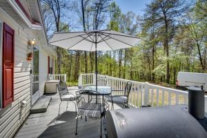 patio con tavolo, sedie e ombrellone di Secluded Hayesville Cabin Rental with Deck and Grill! a Hayesville