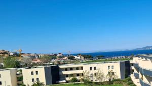 - une vue sur un bâtiment avec l'océan en arrière-plan dans l'établissement APPARTEMENT CORSE PORTICCIO, à Porticcio