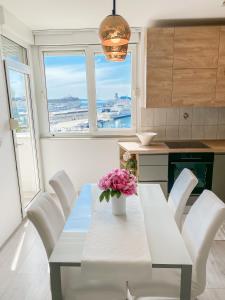 Homey apartment with a view في سبليت: مطبخ مع طاولة عليها إناء من الزهور