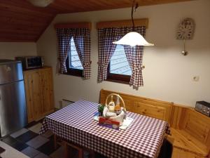 a kitchen with a table with a checkered table cloth at Apartment Zeleni dragulj Pohorje in Oplotnica