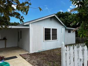 a white shed with a white picket fence at Maria's Farm House in Homestead