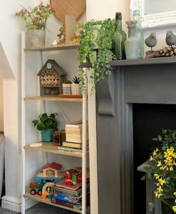 a book shelf next to a fireplace with books at Emily House in Redcar