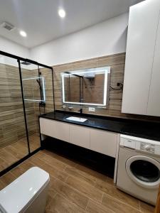 y baño con lavabo y lavadora. en Sea View Apartment Durres, en Durrës