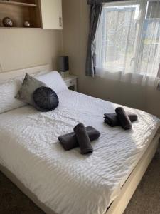 a bed with two slippers on top of it at Beautiful Spacious Holiday Home - Romney Sands in New Romney