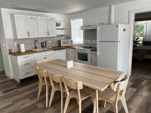Maria's Farm House في هومستيد: مطبخ مع طاولة خشبية وثلاجة بيضاء
