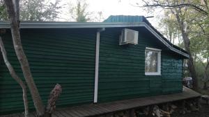 a green house with a porch and a window at FREEDOM 2 in Gornji Štoj