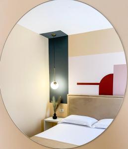 einen Spiegel, der ein Schlafzimmer mit einem Bett reflektiert in der Unterkunft Phi Apartments 1 min from the beach - New Additions in Durrës