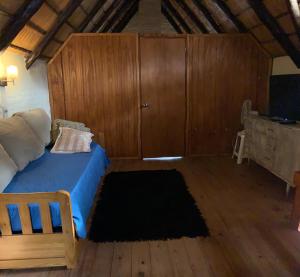 1 dormitorio con 1 cama y suelo de madera en maktub, en Punta del Este