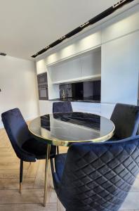 een glazen tafel en stoelen in een keuken bij Marina Apartments in Gdańsk