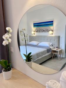 a bedroom with a bed and a mirror at ATHANASIA APARTMENTS in Skiathos