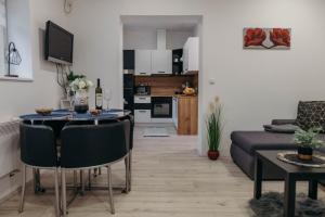 een woonkamer en een keuken met een tafel en een bank bij HOLY in Ðakovo