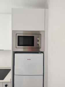 un forno a microonde seduto sopra un frigorifero di Racó de Mar a Palamós