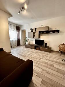Una sala de estar con un sofá y un televisor de pantalla plana. en Balconi Bellavista, en Cefalú