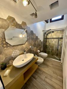 Un baño con lavabo, inodoro y ducha. en Balconi Bellavista, en Cefalú 24 fotos más
