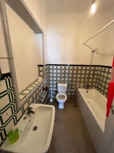 La salle de bains est pourvue d'un lavabo, de toilettes et d'une baignoire. dans l'établissement Fernando Guest House, à Aveiro