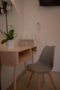 a desk with a chair and a mirror at ATHANASIA APARTMENTS in Skiathos