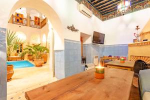 een woonkamer met een houten tafel en een zwembad bij SABOR SAFRA in Marrakesh
