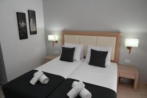 una camera da letto con un grande letto bianco con due cuscini di ANGELA STUDIOS a Kremasti