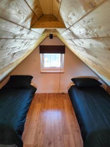 2 łóżka w małym pokoju z oknem w obiekcie Na Zaciszu w mieście Cierzpięty