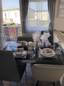 a dining room table with plates of food on it at Beautiful Spacious Holiday Home - Romney Sands in New Romney