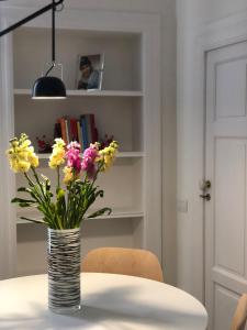 a vase of flowers sitting on top of a table at Dimora Savoia in Corato