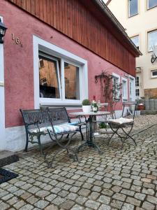 un patio avec un banc et une table ainsi qu'un bâtiment dans l'établissement Urlaub im Friseursalon, à Sebnitz