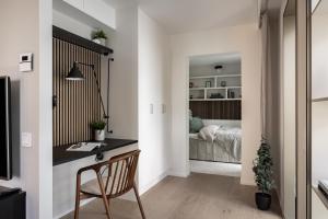 ein Heimbüro mit einem Schreibtisch und einem Bett in einem Schlafzimmer in der Unterkunft Norra Station Executive Suite - 3km from City Centre in Stockholm