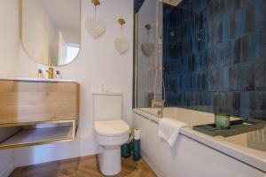 a bathroom with a toilet and a sink and a mirror at Priory Bay Escapes - Matahari in Tenby