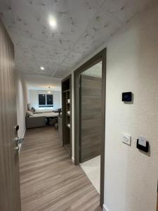 um quarto com um corredor com uma porta e uma sala de estar em Musieges Appart'Hôtel 