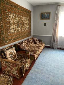 a living room with a couch and a rug at Заміський будинок in Rzhyshchiv