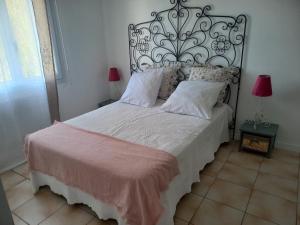 um quarto com uma cama grande e uma cabeceira de metal em L'EN HAUT em Aramon