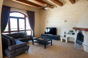 een woonkamer met een bank en een open haard bij VillaNirvana in Qala