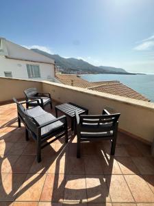 a balcony with tables and chairs and the ocean at Balconi Bellavista in Cefalù